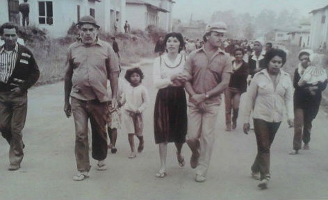 Foto antiga em preto e branco: moradores caminhando juntos pela rua do Centre Ville, na época da ocupação